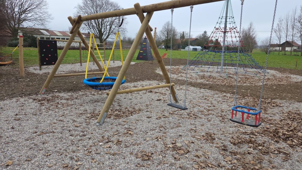 Kinderspielplatz in Reichersberg mit Vogelnestschaukel und großem Seilkletternetz.